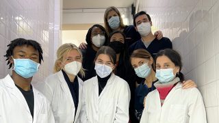 A group of eight undergraduates wearing masks pose together in a group picture while completing an internship in Argentina.