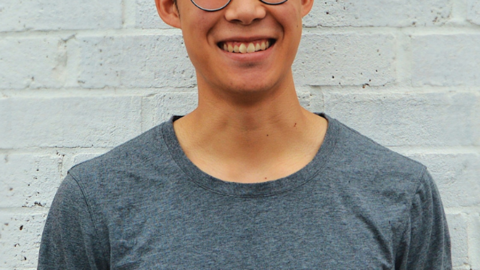An image of Phil Wong, an alumnus and creator of a food startup, wearing a gray T-shirt and glasses.