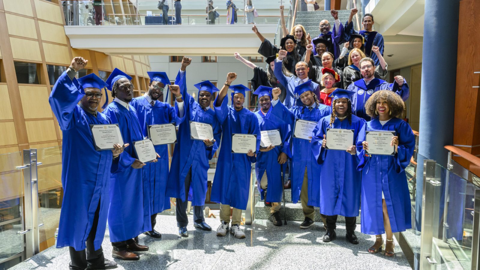 An image of graduates from the Pivot Program wearing blue cap and gowns.