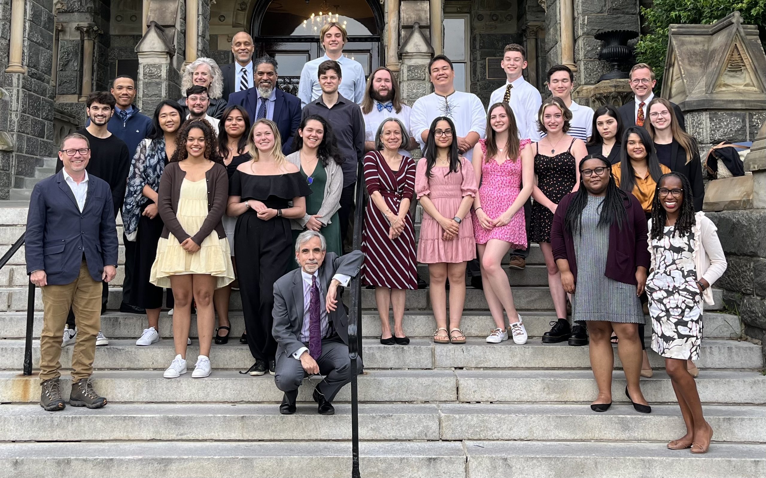 19 students from Georgetown's Predoctoral Summer Institute gather for a group photo on the steps of Healy Hall.