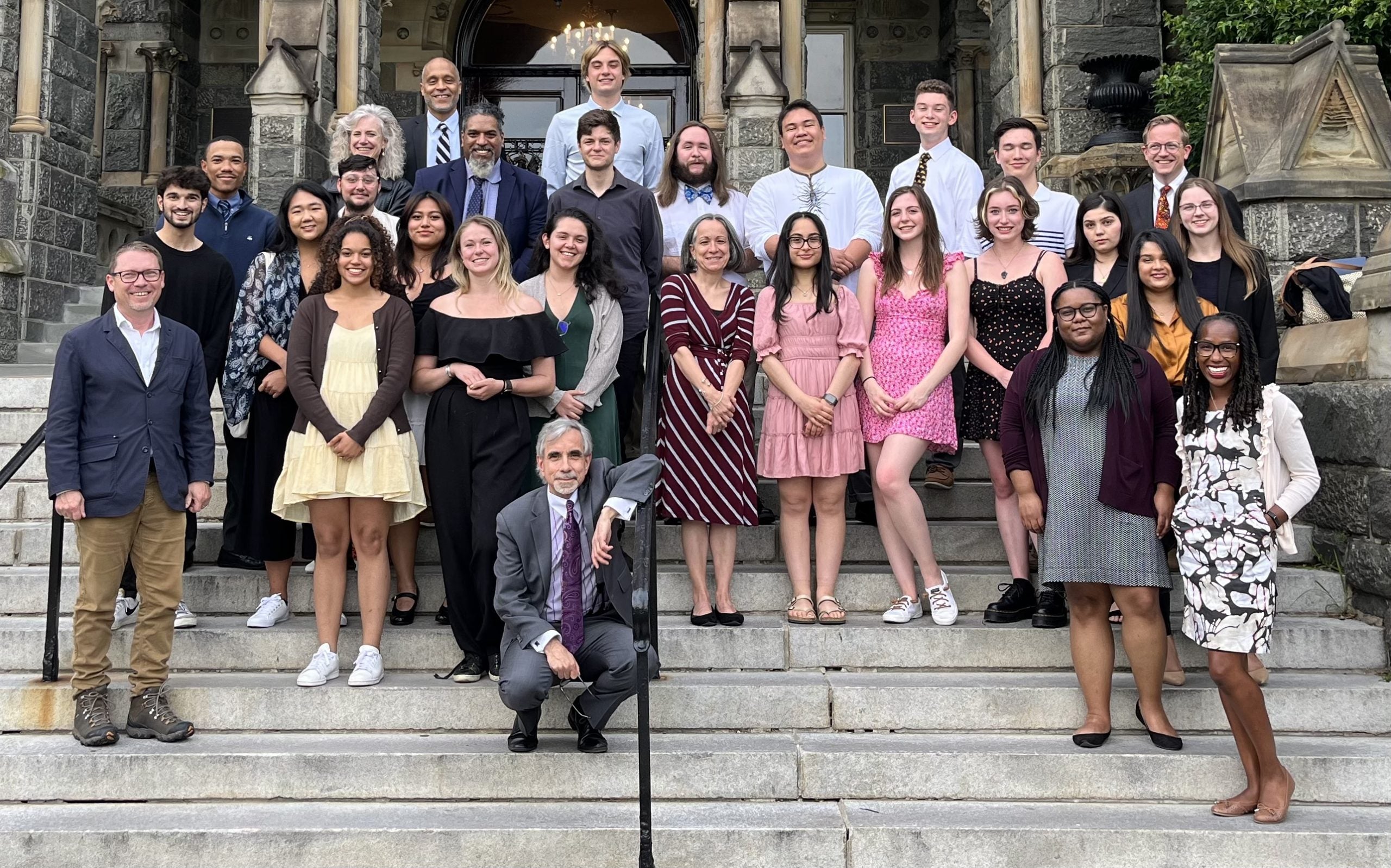 19 students from Georgetown's Predoctoral Summer Institute gather for a group photo on the steps of Healy Hall.