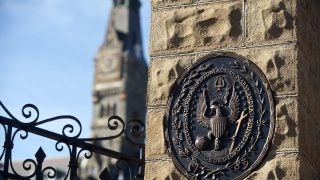 An image of Georgetown&#039;s seal on a pillar at the gates of the university&#039;s campus.