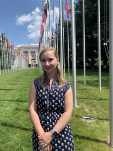 Kate Barranco (SFS'23) stands in front of the United Nations surrounded by flags.
