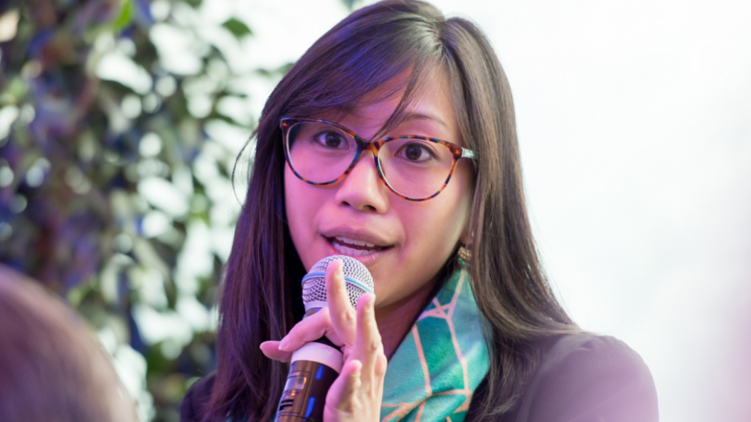 An image of Tiffany Yu (B’10) speaking into a microphone at an event.