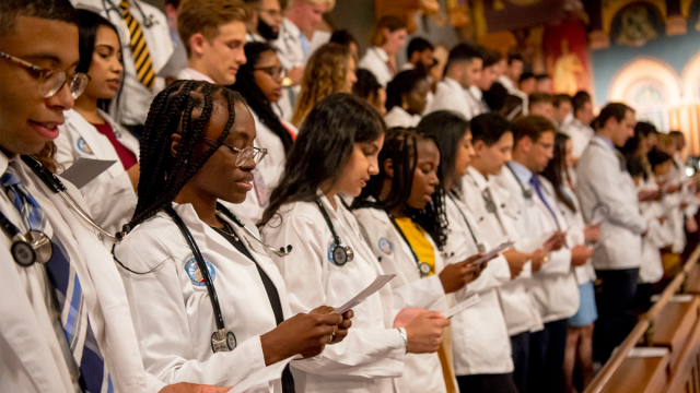 A group of first-year medical students read the Hippocratic Oath at Georgetown's annual White Coat Ceremony in Gaston Hall.