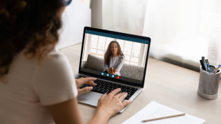 A student engages in a video conversation with another student on a laptop.