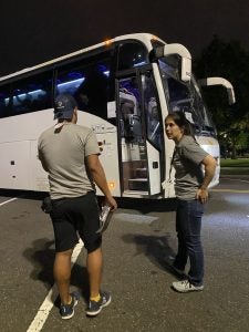 Jackie Lamas, a graduate student, stands outside a bus of migrants and refugees who were arriving at Union Station one night in July.