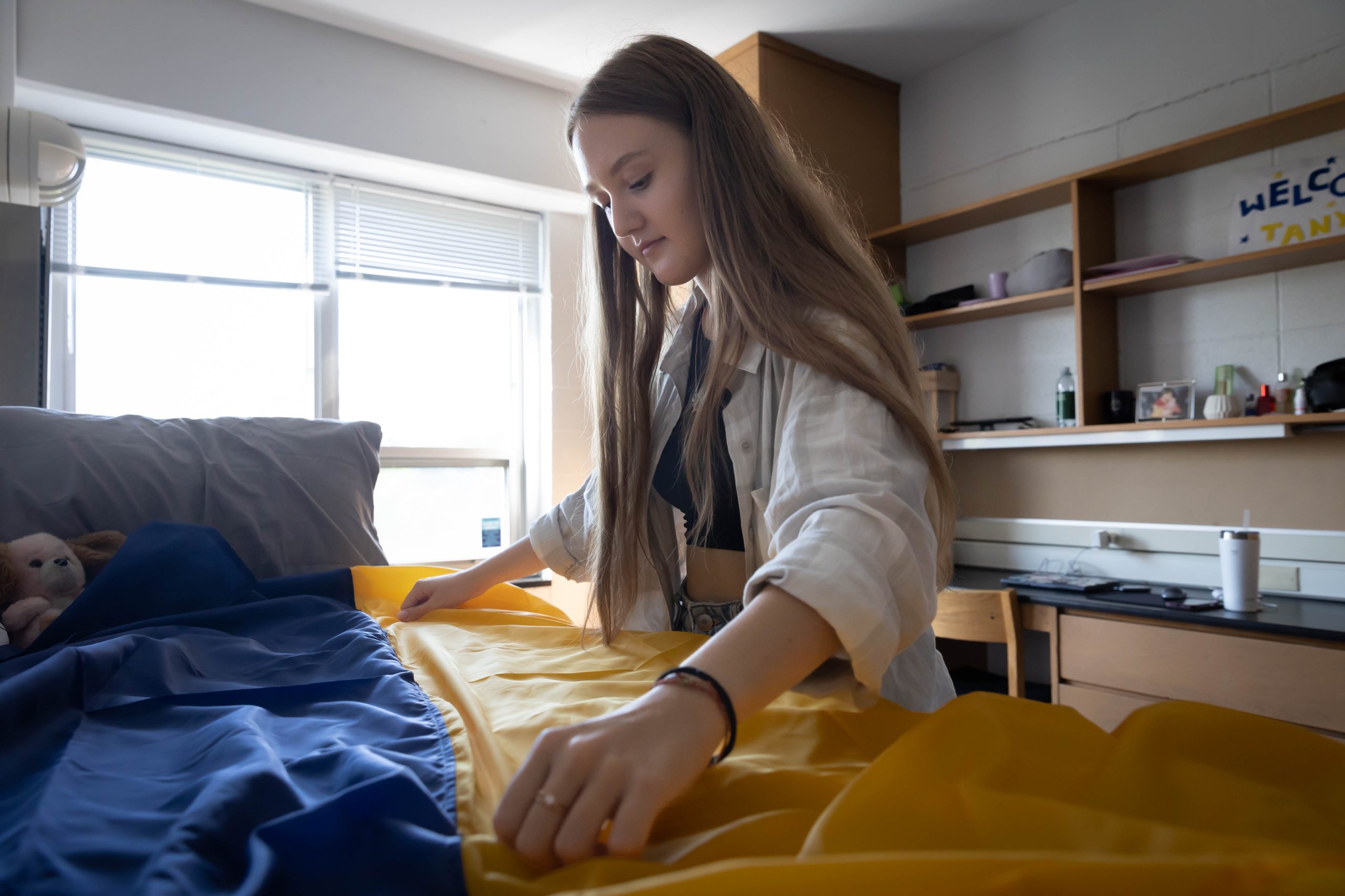 Tanya Tkachemko (SFS’23) prepares to hang a Ukrainian flag over her bed in her dorm room.