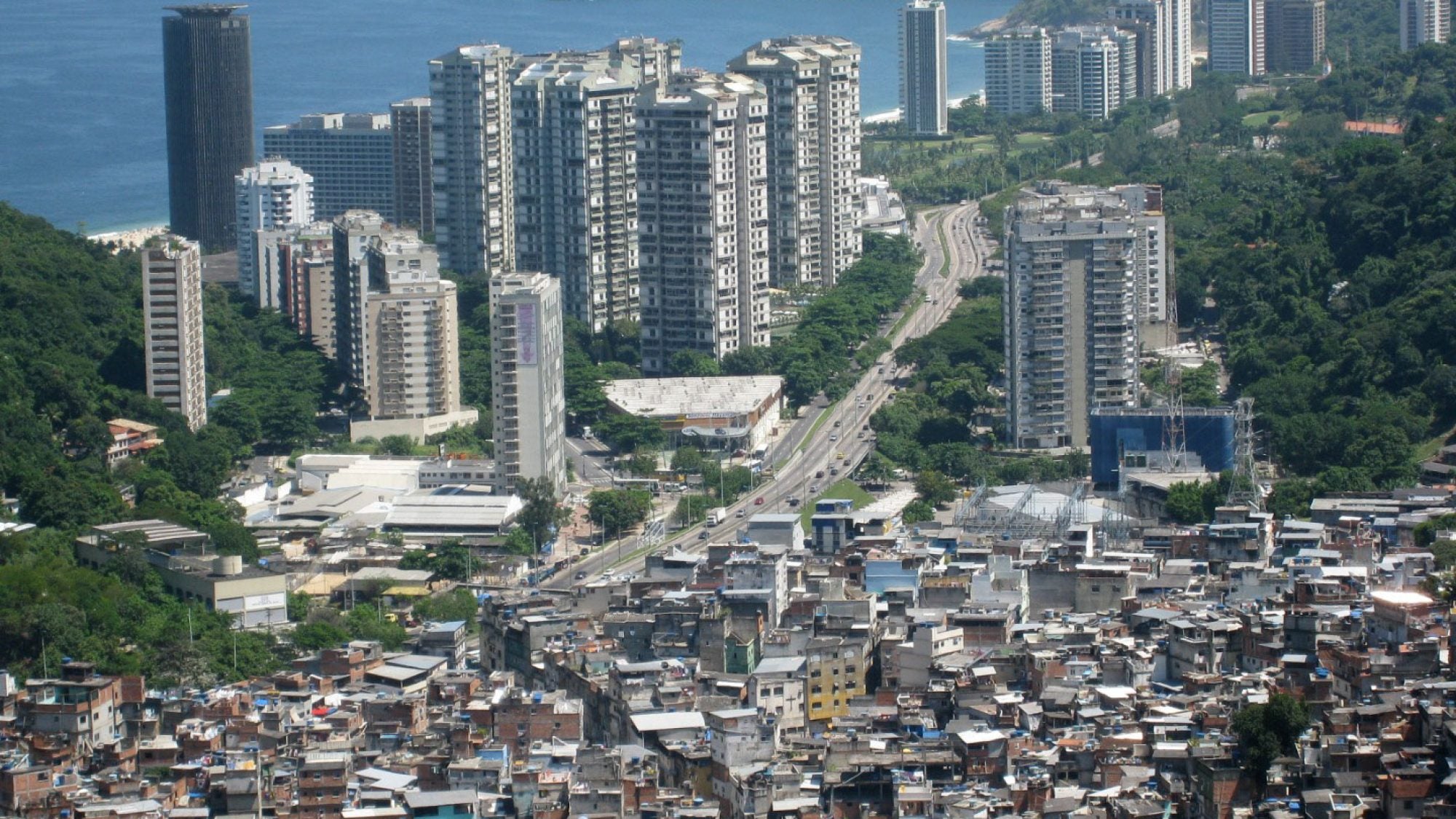 Grey skyscrapers across a highway from a favela in Brazil