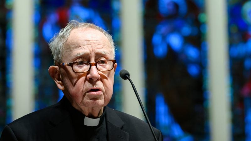 Fr. O&#039;Malley speaks from a podium in front of blue stained glass