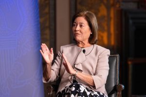 Mayu Ávila raises her hands while speaking on a panel onstage