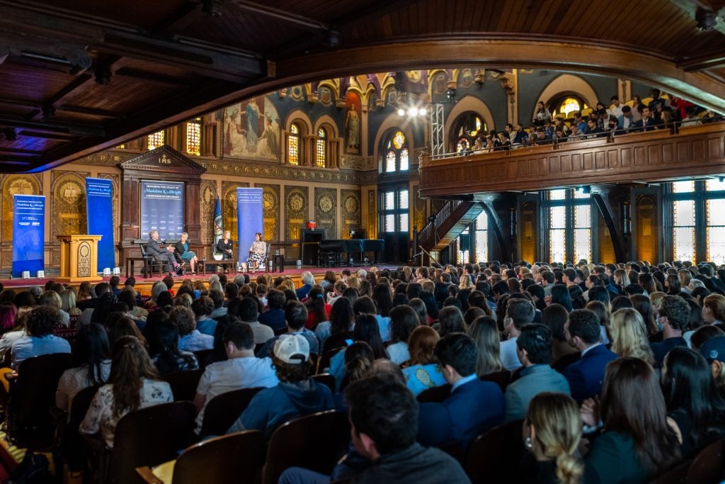 Crowd in Gaston Hall watches a panel of former foreign ministers.