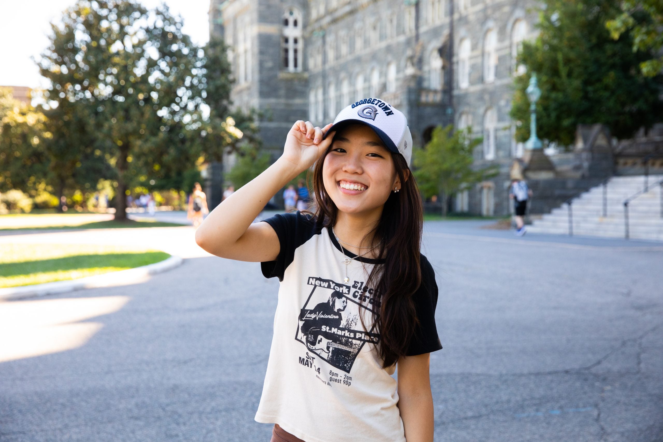Young woman in a Georgetown T-shirt and hat outside
