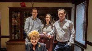 Christopher Mohr (MSFS’24, L’24) (left), Vanessa Jarnes (MSFS’23, MBA’23) (center) and Darren Hall (MSFS’22, MBA’22) (right) stand behind Madeleine Albright in her office.