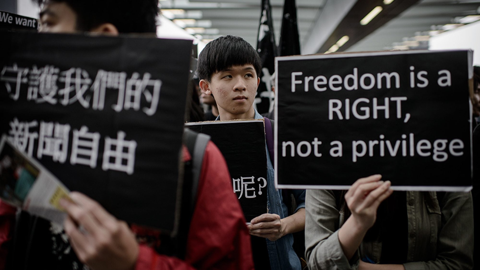 Protesters display placards during a rally to support press freedom.