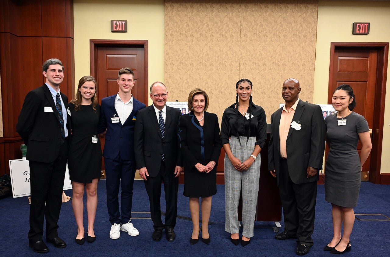 Georgetown students stand with Nancy Pelosi and Georgetown President John J. DeGioia