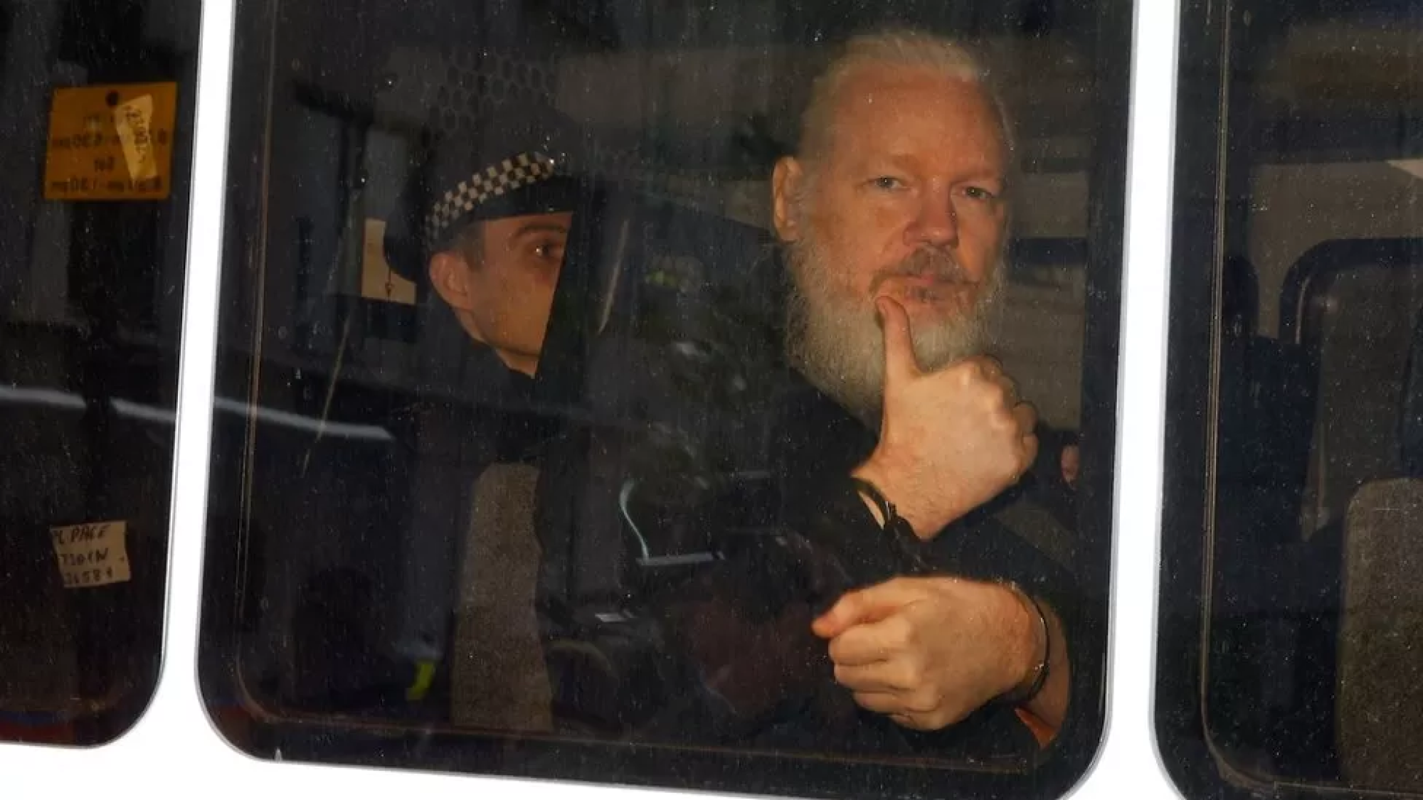 Assange gave a thumbs up as he was taken to Westminster Magistrates' Court in a police van