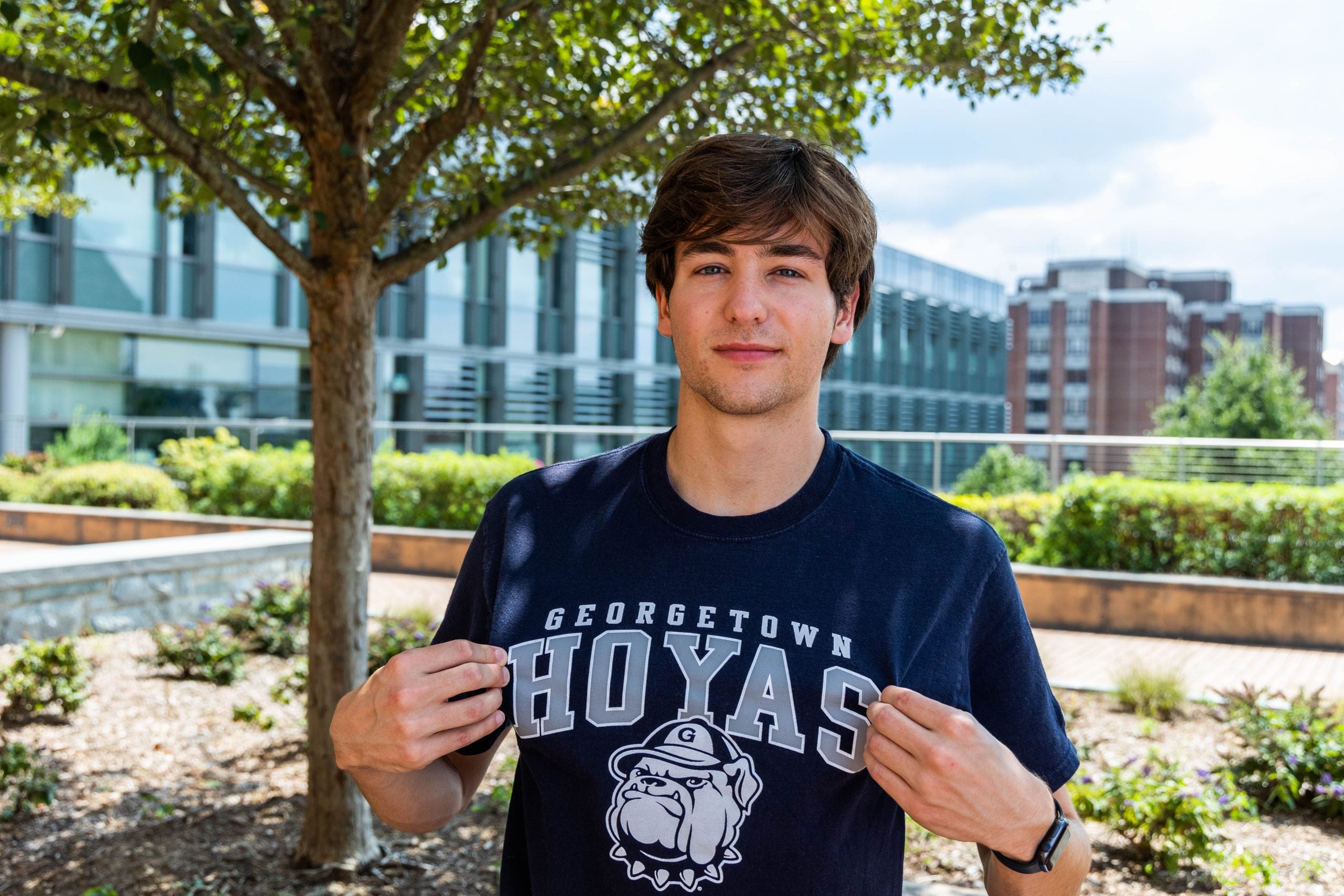 Young Man lifts up the Georgetown Hoyas part of his T-shirt