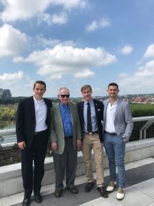 Three young men stand on either side of Fr. O'Malley, who wears sunglasses