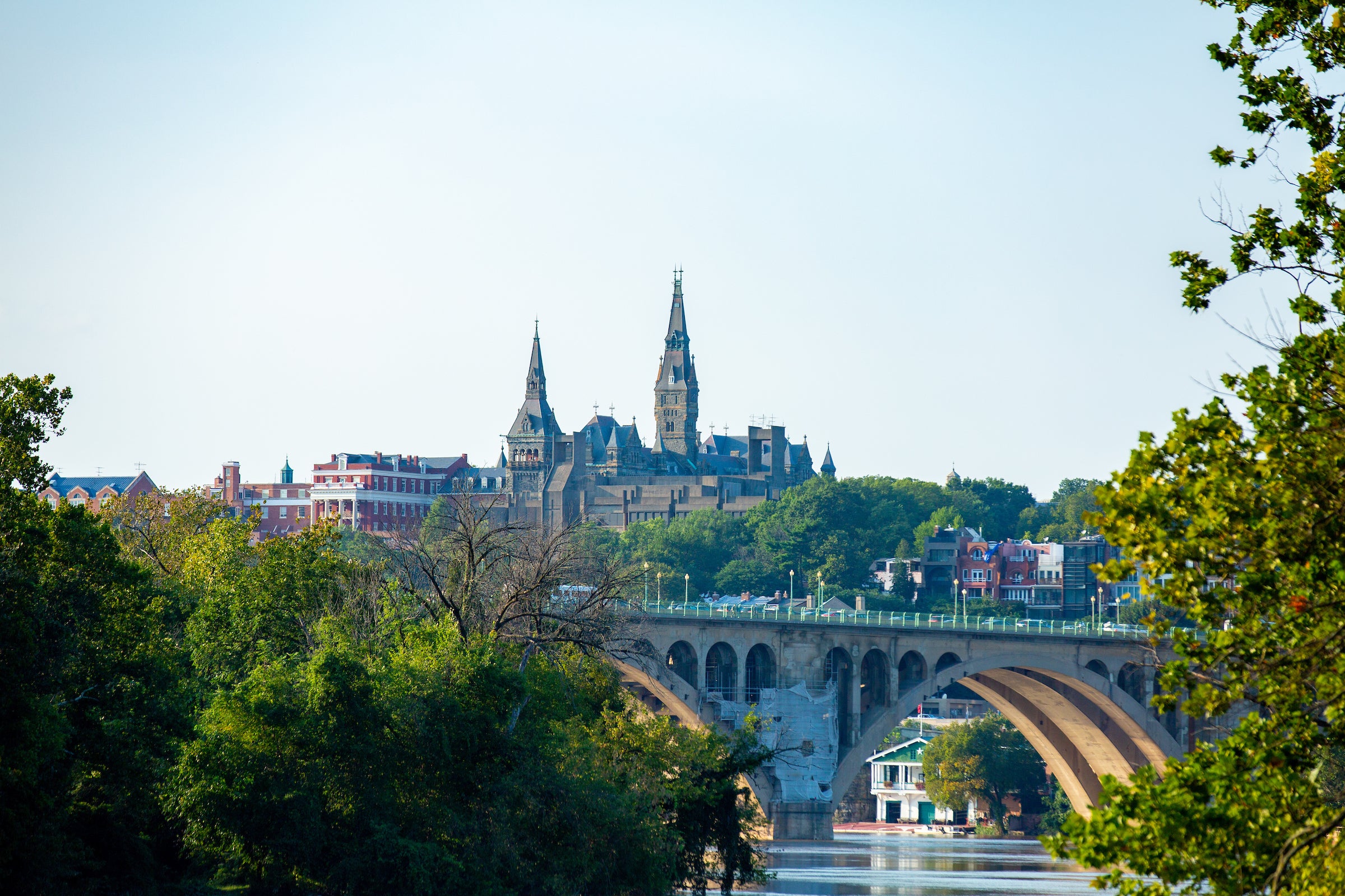 Skyline of Georgetown's campus and Healy Hall towers behind Key Bridge at sunset