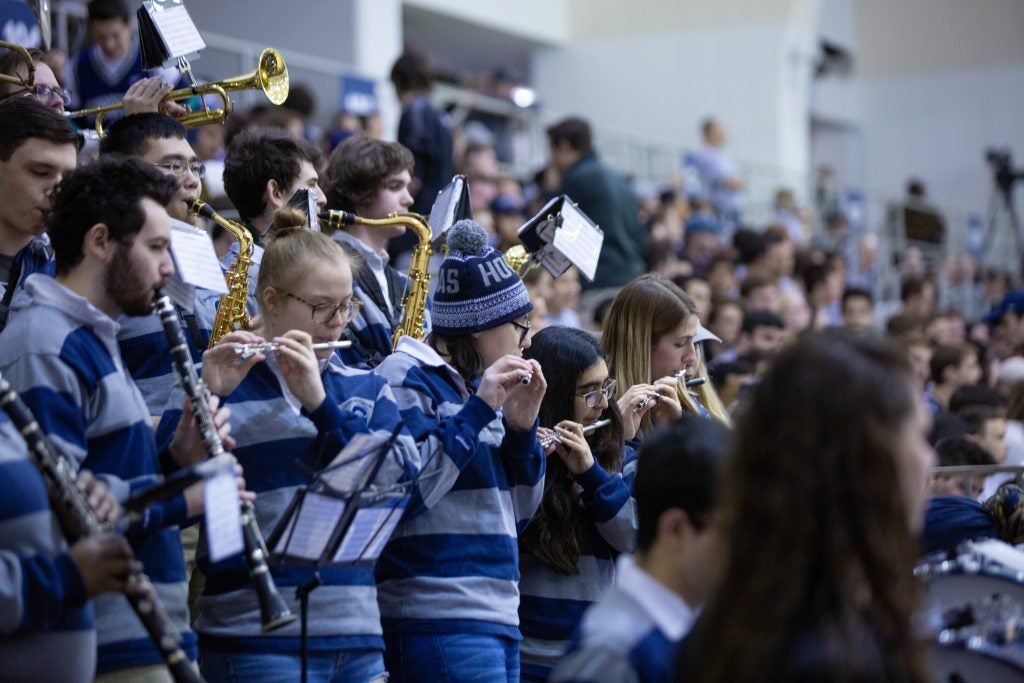 Members of the clarinet section in Georgetown's Pep Band wear striped shirts and play their instruments at a 2019 basketball game