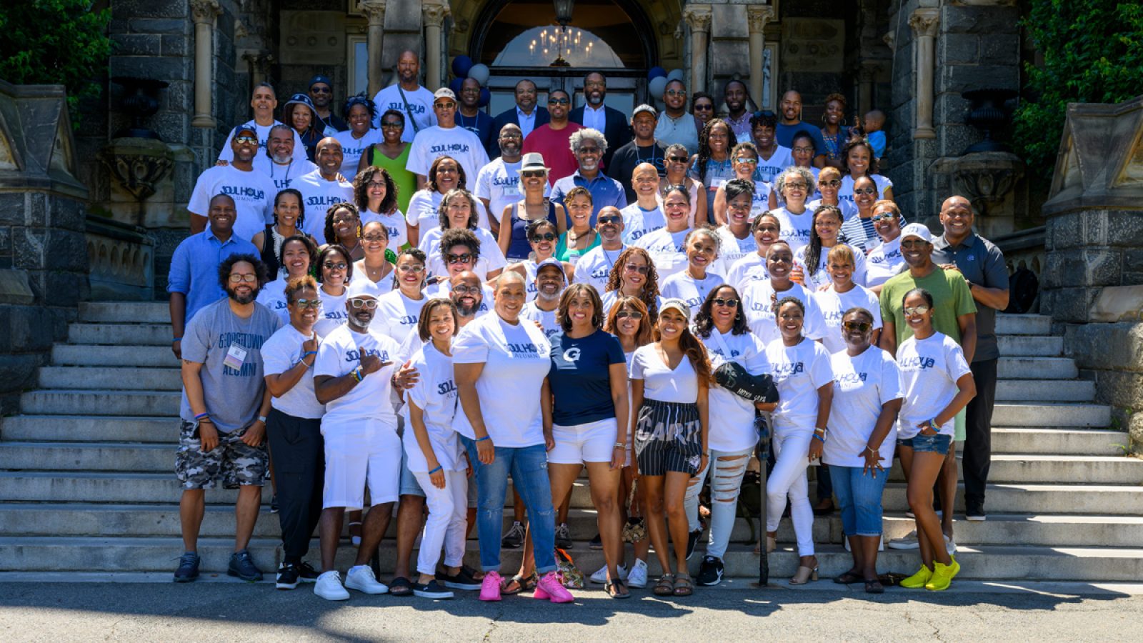 Members of the organizes the Soul Hoyas pose for a picture on the steps of Healy Hall during their annual reunion event. Many of the group members wear white T-shirts that say, &quot;Soul Hoya Alumni&quot;