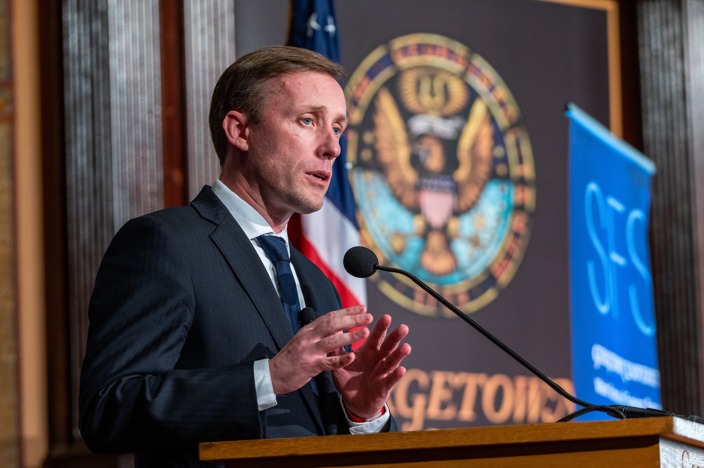 Jake Sullivan speaks from behind a podium in front of a Georgetown seal