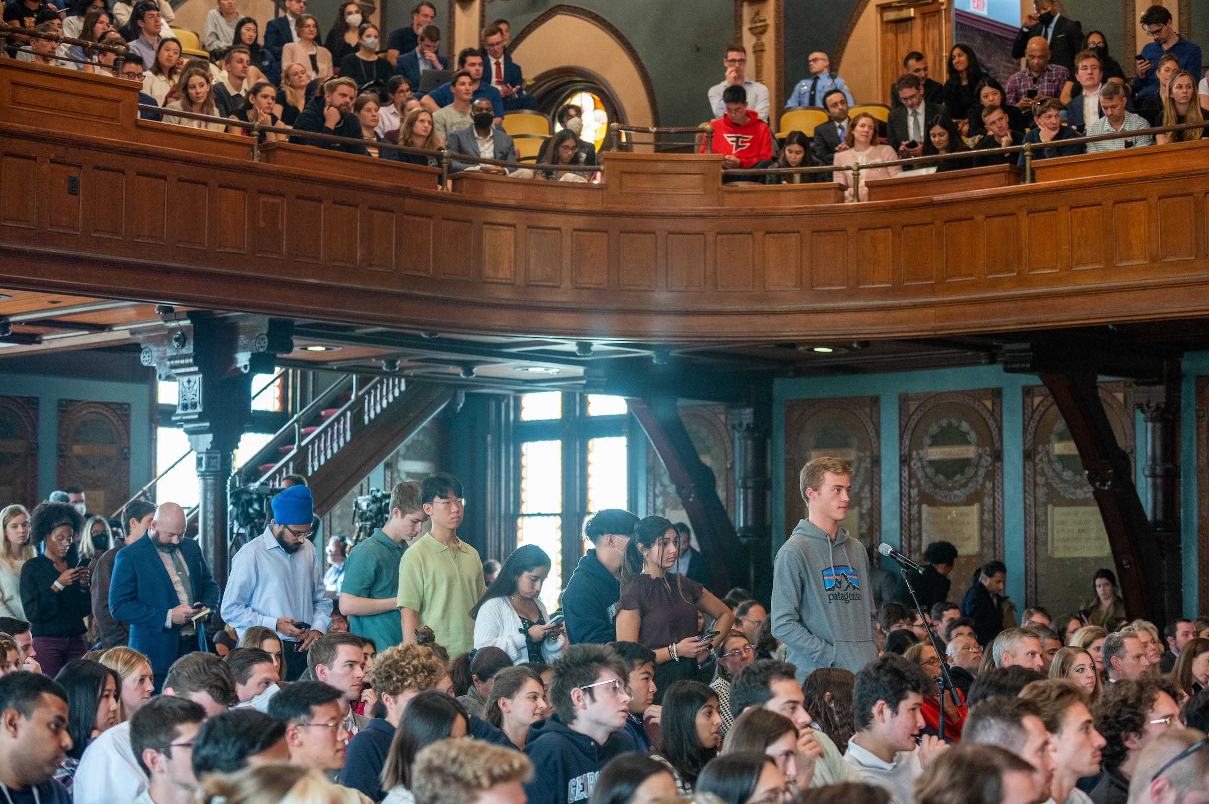 Students line up to ask questions among a crowded Gaston Hall