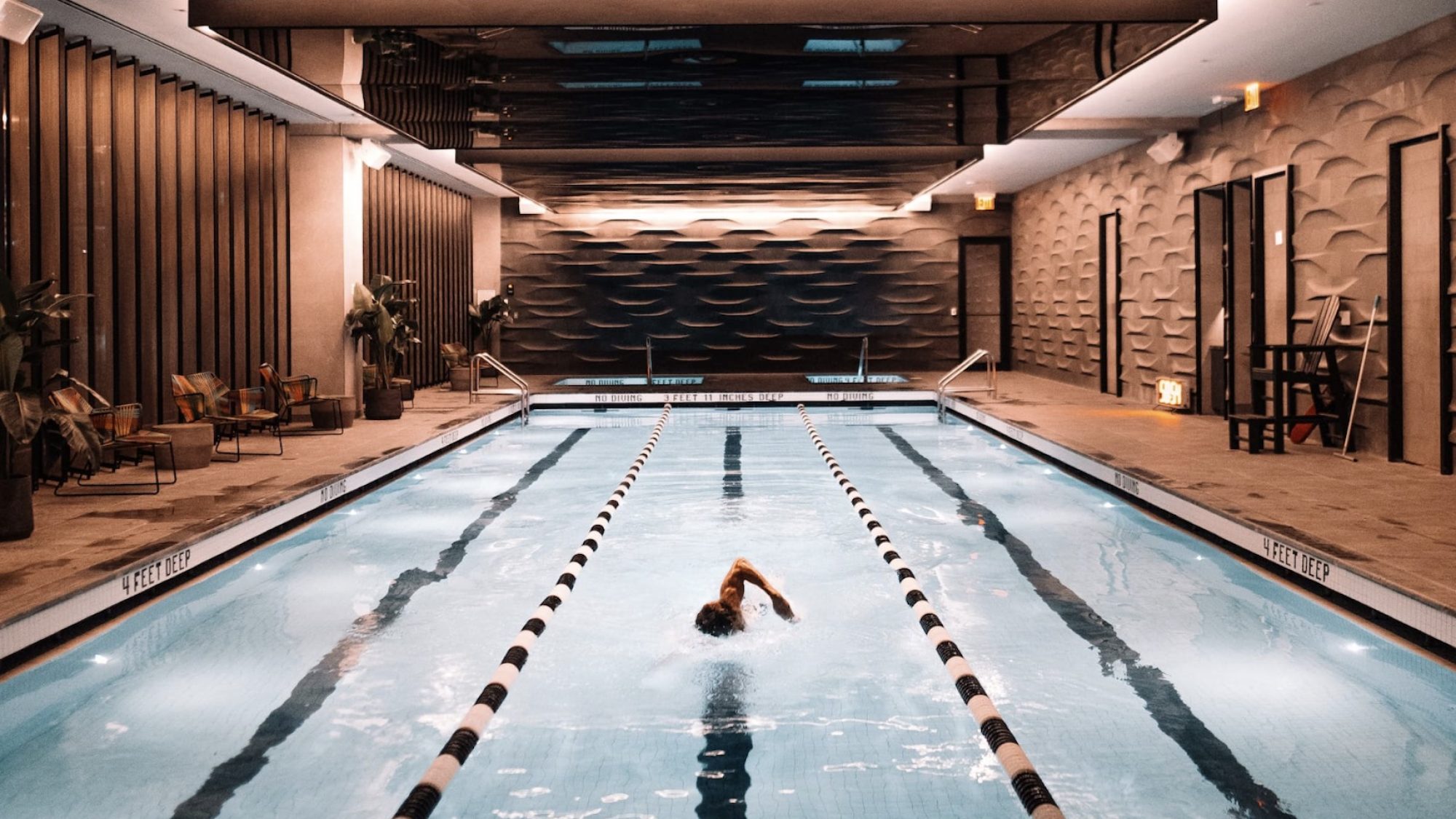 Indoor swimming pool with single lap swimmer.
