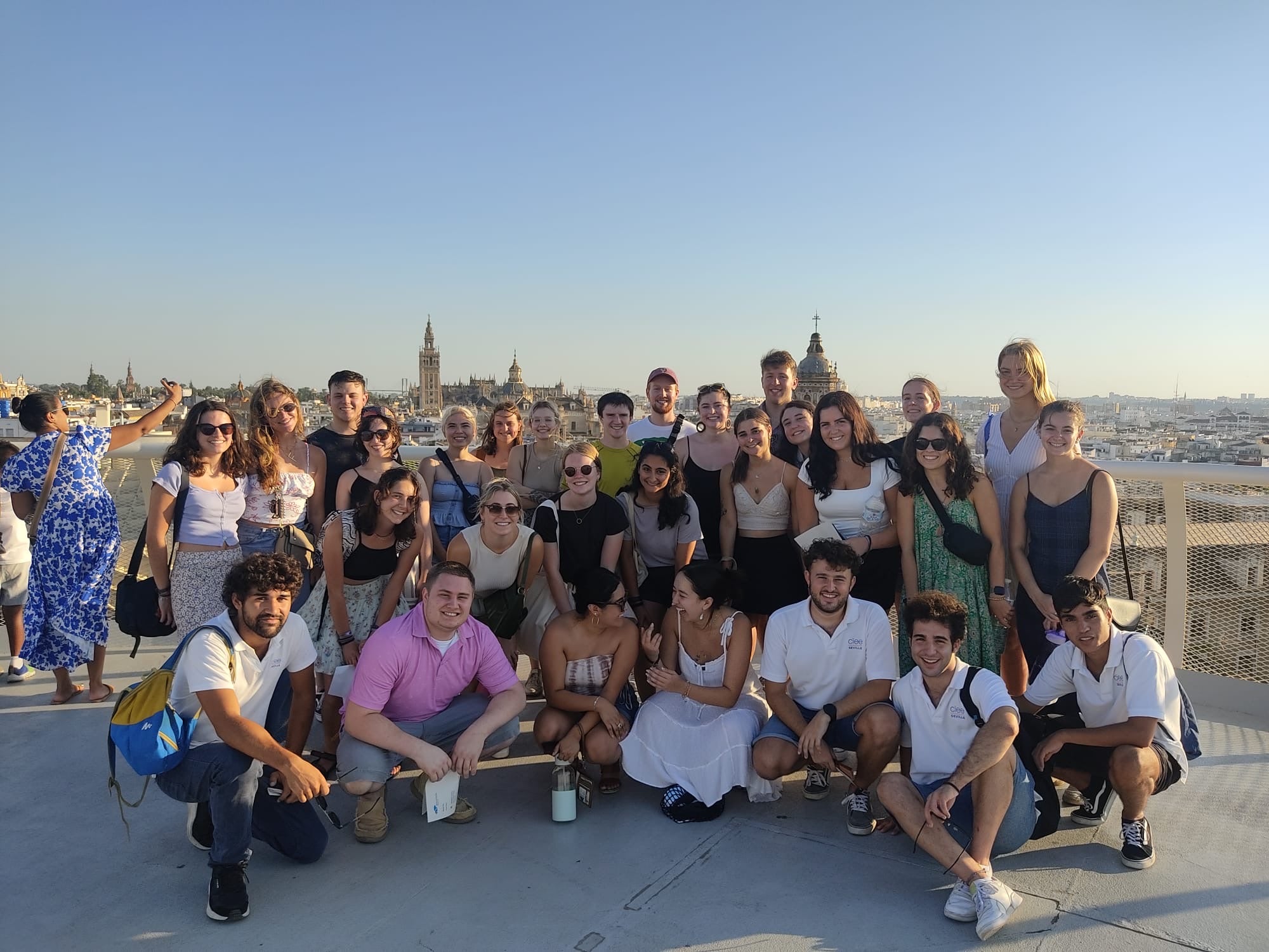 Study abroad students pose for a group photo with the city behind them