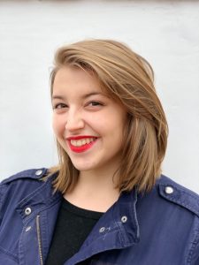 Isabella Turilli has shoulder-length blonde hair and wears red lipstick and a blue jacket
