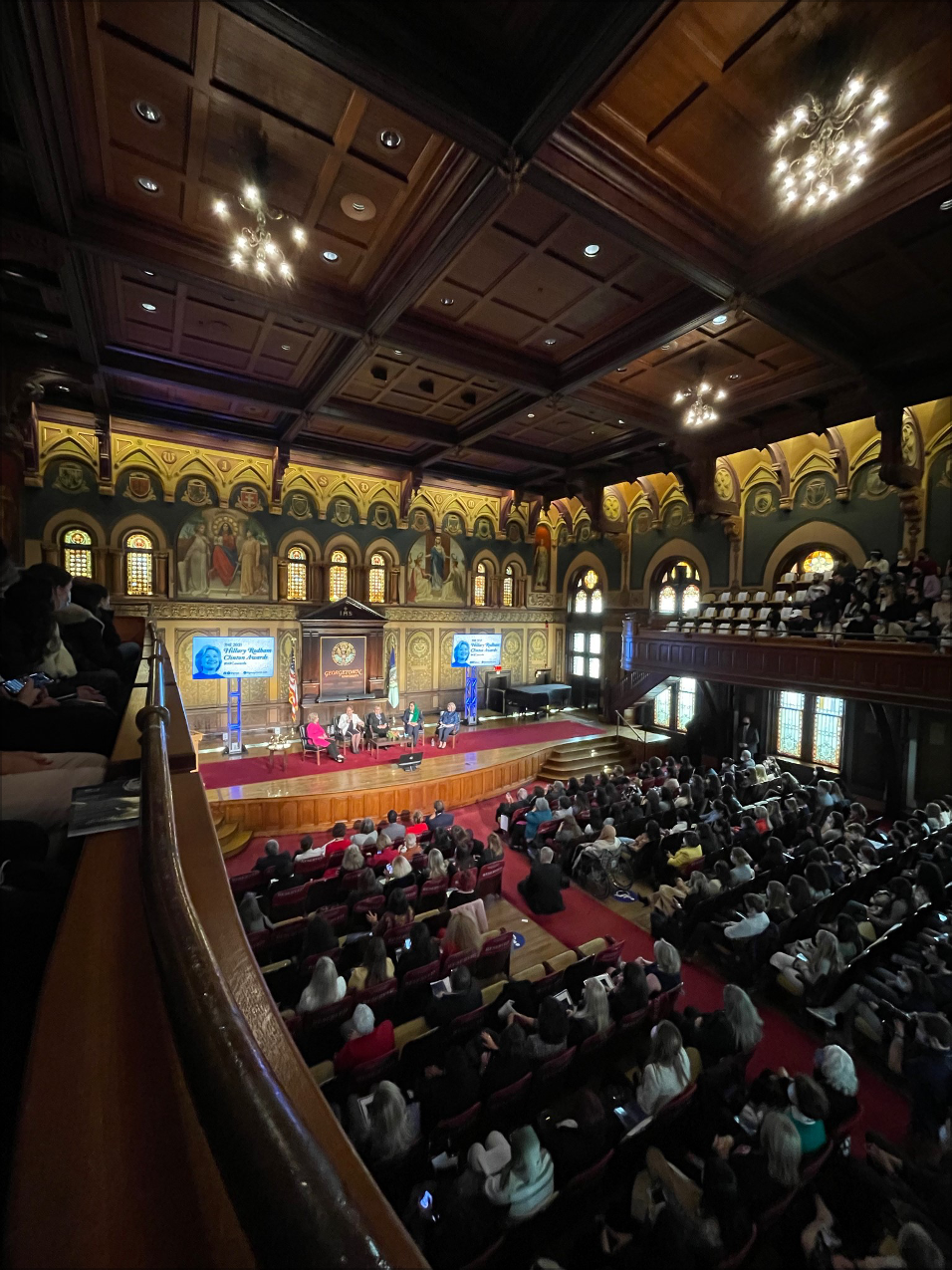 Audience watches panelists on stage.