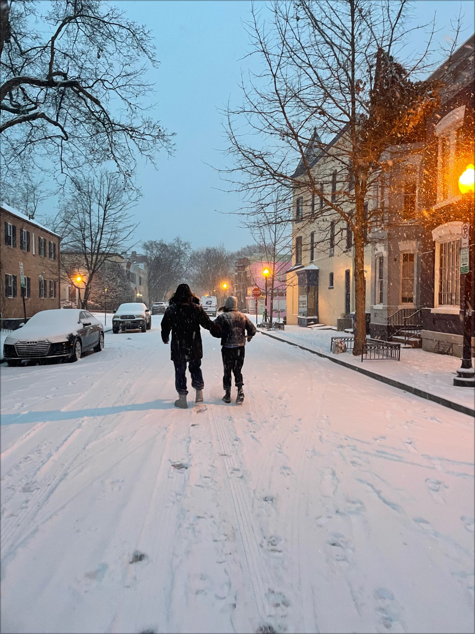 Two people walking on the snowy street
