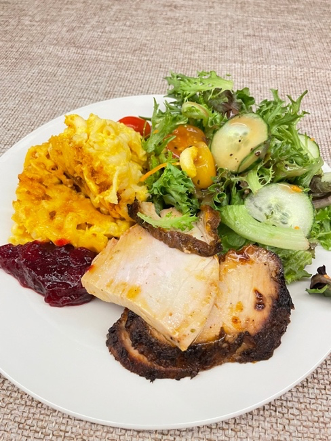 Thanksgiving meal featuring turkey, salad, cranberry sauce, and mac & cheese