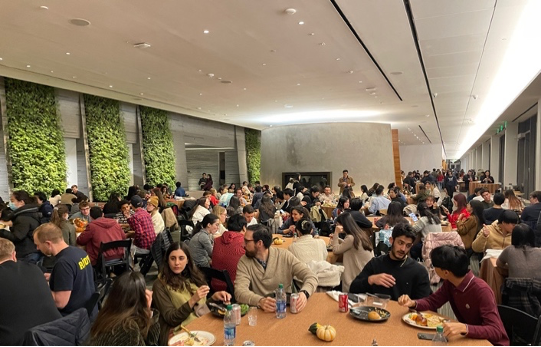 Photo of the crowd attending dinner, eating and socializing