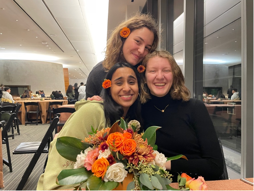 Alara and two friends smiling with flowers in their hair