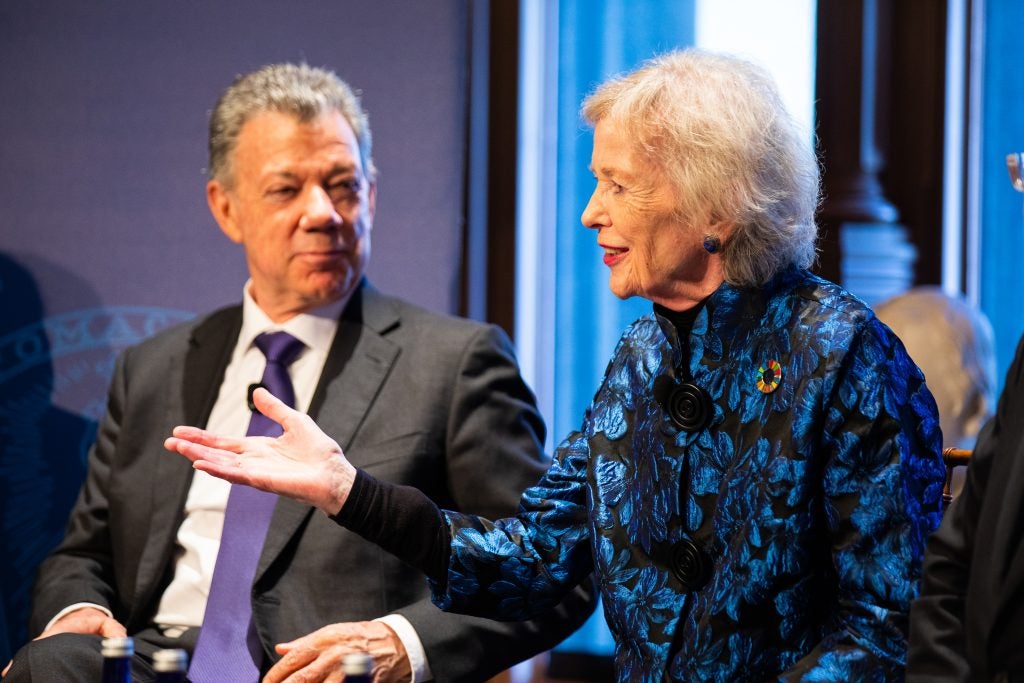 Mary Robinson, the first woman president of Ireland and former United Nations high commissioner for human rights, holds out her palm in a gesture as she speaks on a panel at a Georgetown event on Jan. 24. She is wearing a blue and black-patterned jacket with a rainbow-colored circle pin.