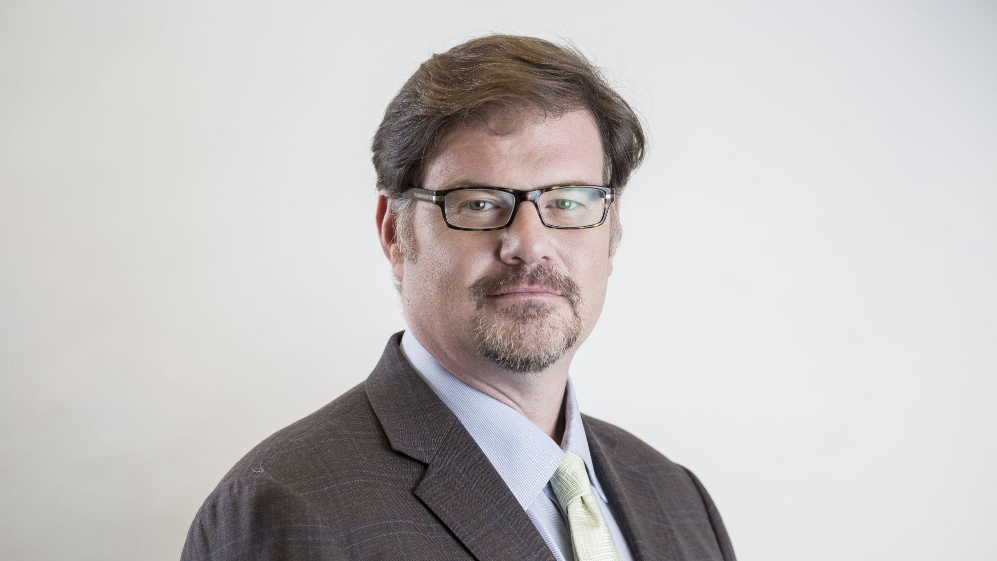 Jonah Goldberg, in suit and wearing glasses, looking at camera.