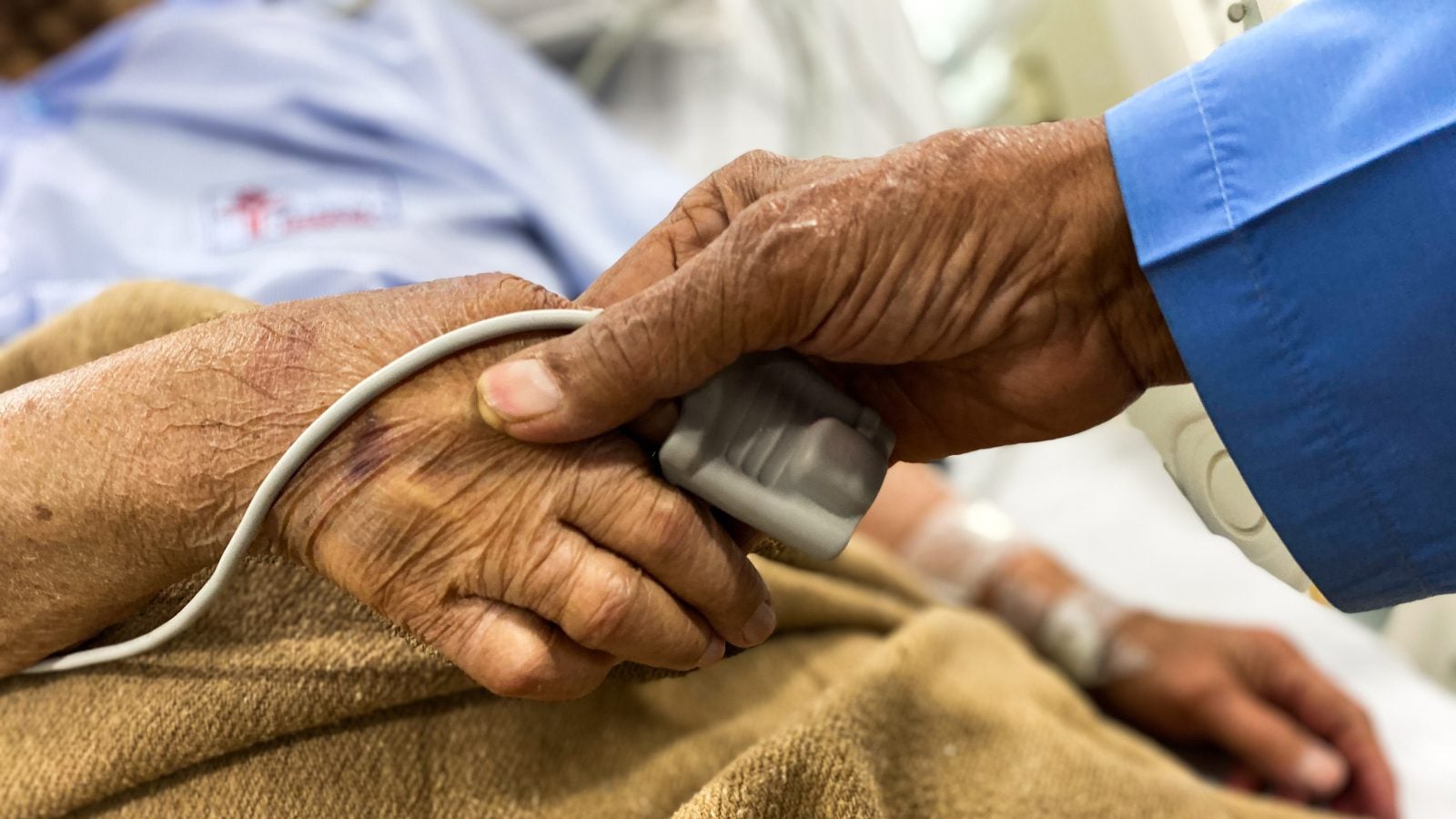 Old couple holding hands in hospital