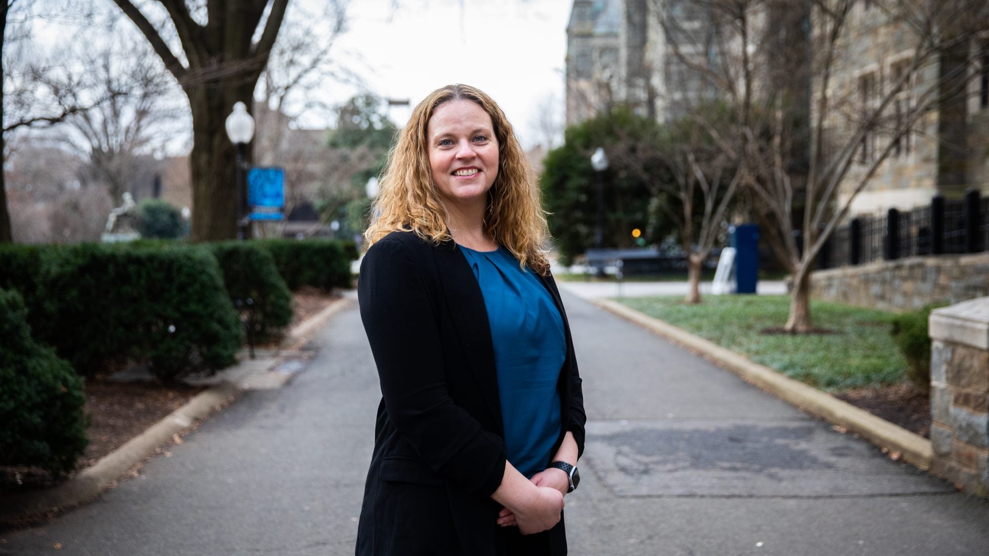 Jessica Ballou smiles with hands folded on a winter day outside of Copley Hall.