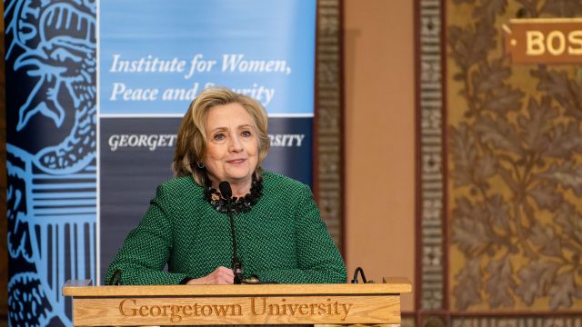 Hillary Clinton speaks at podium in Gaston Hall.