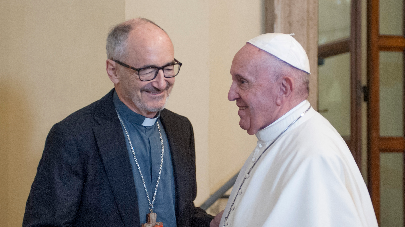 Cardinal Michael Czerny, S.J. on left shaking hands with Pope Francis on right