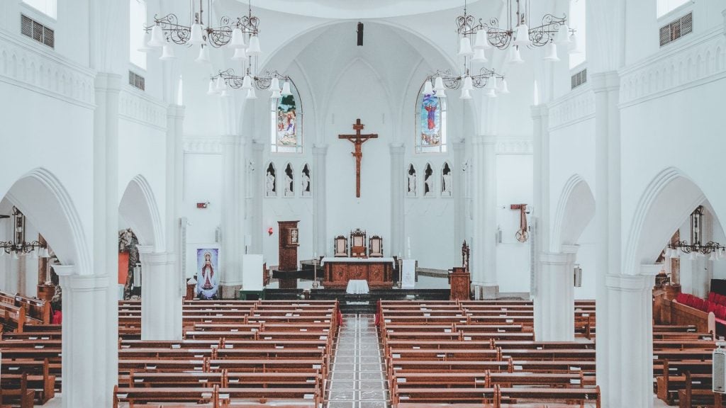 Church altar and pews, with a cross at the center.