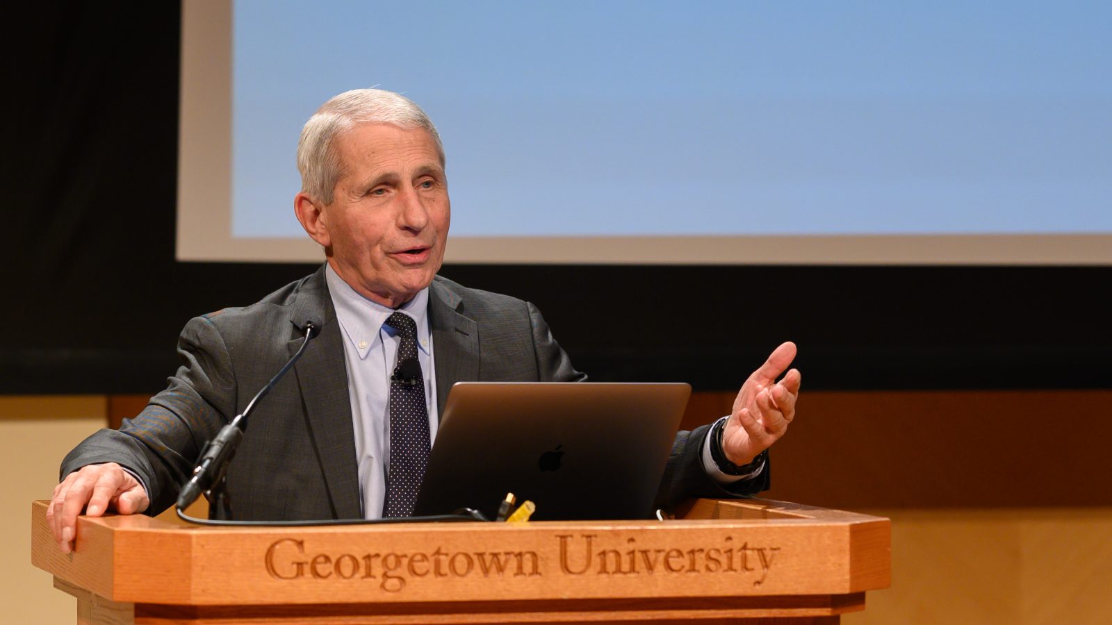 Dr. Anthony Fauci delivers a presentation at a podium in the Lohrfink Auditorium