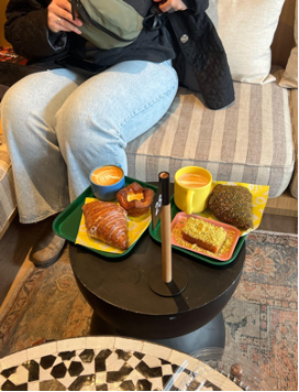 Variety of croissants and pastries on table by comfy sofas