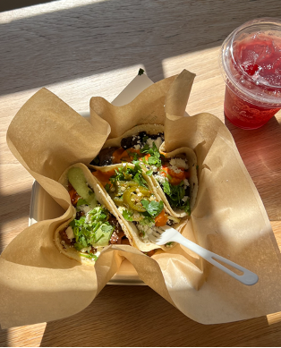 photo of 3 sweet potato tacos, topped with cilantro and pico, all next to a red drink