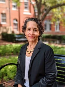 Maria Cancian is dean of the McCourt School of Public Policy at Georgetown. In this picture, she sits outside on a park bench looking at the camera.