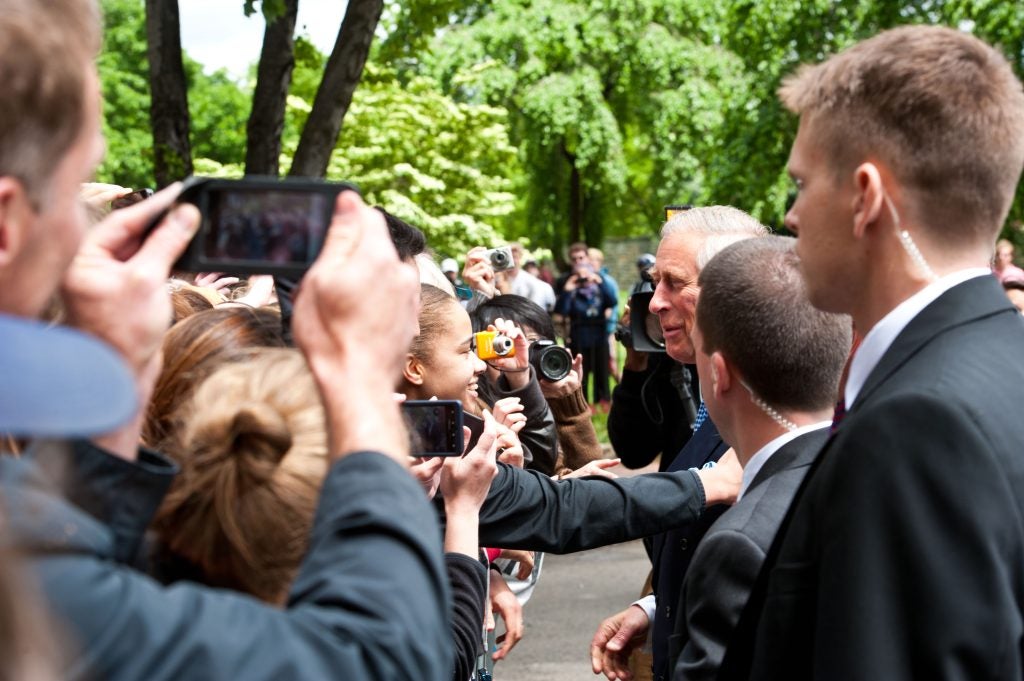 A student in the crowd reaches out to King Charles