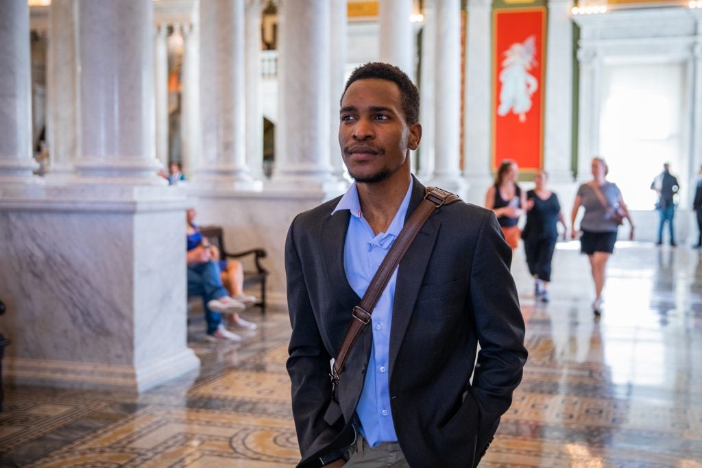 Gandawa walks through a brightly lit hall in the Library of Congress