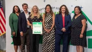 Six people in front of a backdrop accepting an award